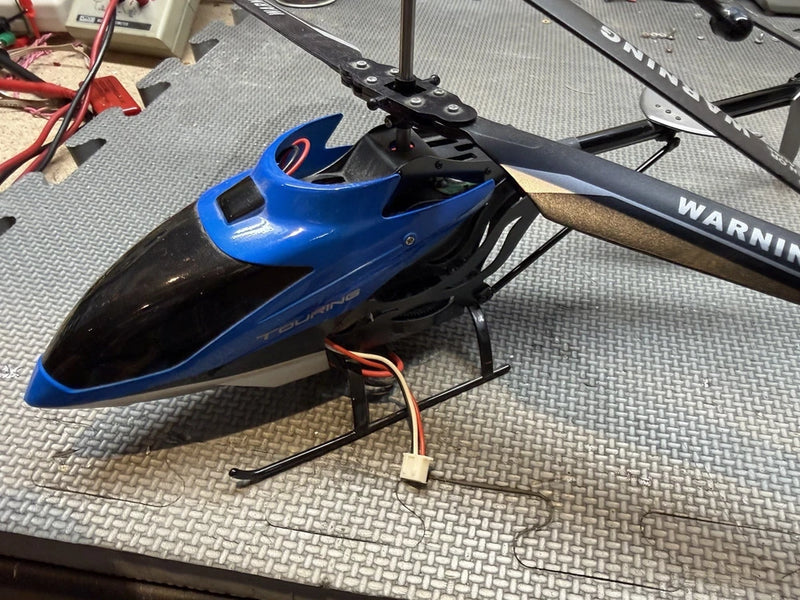 Blue and black RC helicopter fuselage with rotor mast and skids