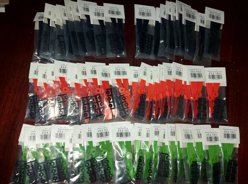 FPV drone propeller set in black, orange, and green bags for racing