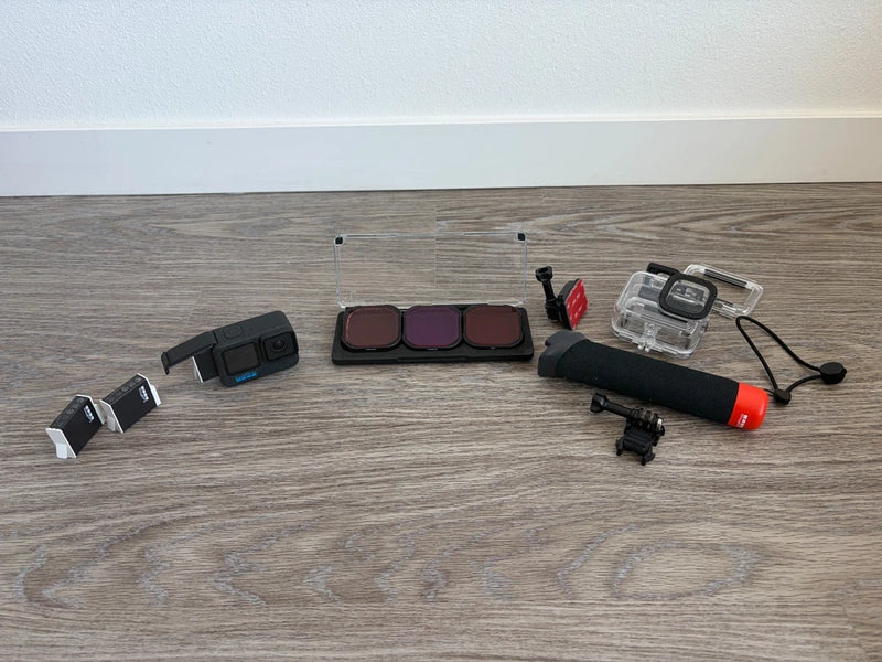 Action camera accessory bundle with protective housing, mounts, and red battery grip
