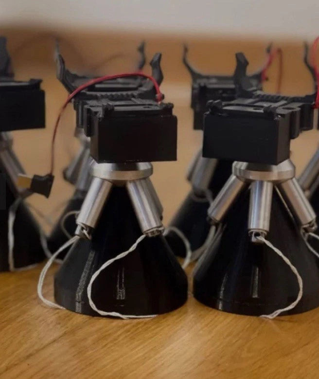 Tactical cartridge launcher with two black cylindrical launch modules on metal stands