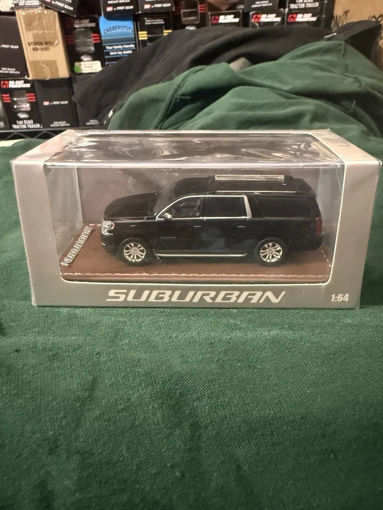 Boxed 1:64 scale Suburban die-cast model truck, black SUV with silver wheels