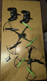 Dark remote video drone with green prop guards and two black controllers