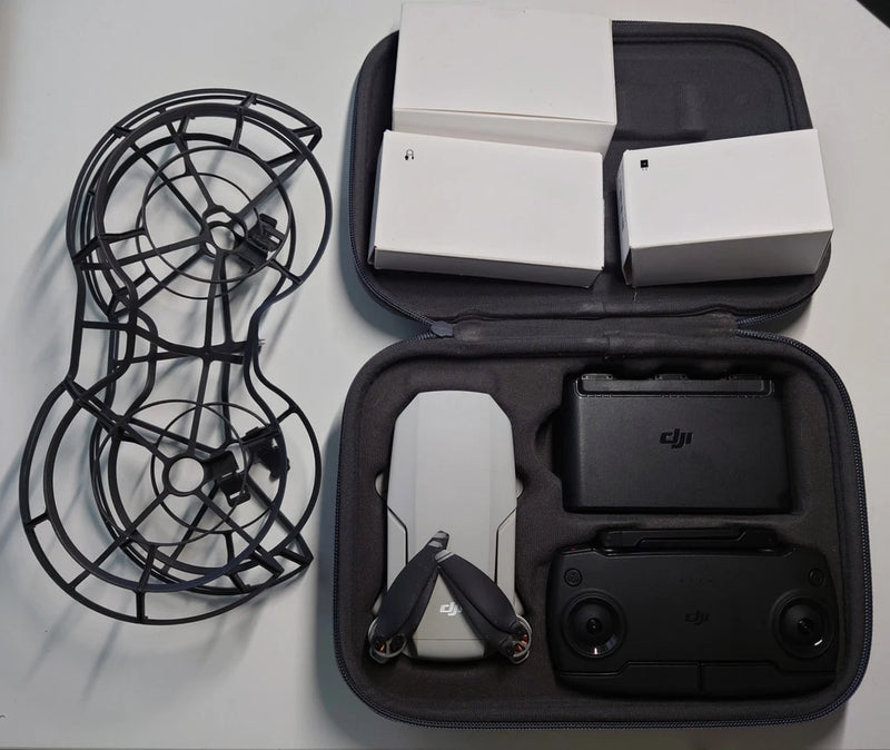 Drone with propeller guards, remote controller, and accessories in zippered case