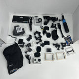 GoPro action camera bundle with multiple mounts, head strap, and spare batteries in box