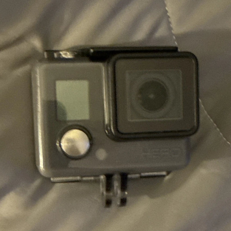 Waterproof action camera with lens and side button, gray/black housing
