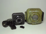 Weatherproof trail camera with black lens module and green camouflage housing