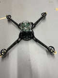 Vintage black quadcopter drone with four arms and central camera/sensor module