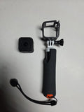 Compact action camera with waterproof housing on black handheld grip mount