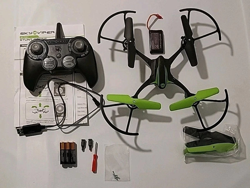 Black and green remote control stunt drone with four propellers and included accessories