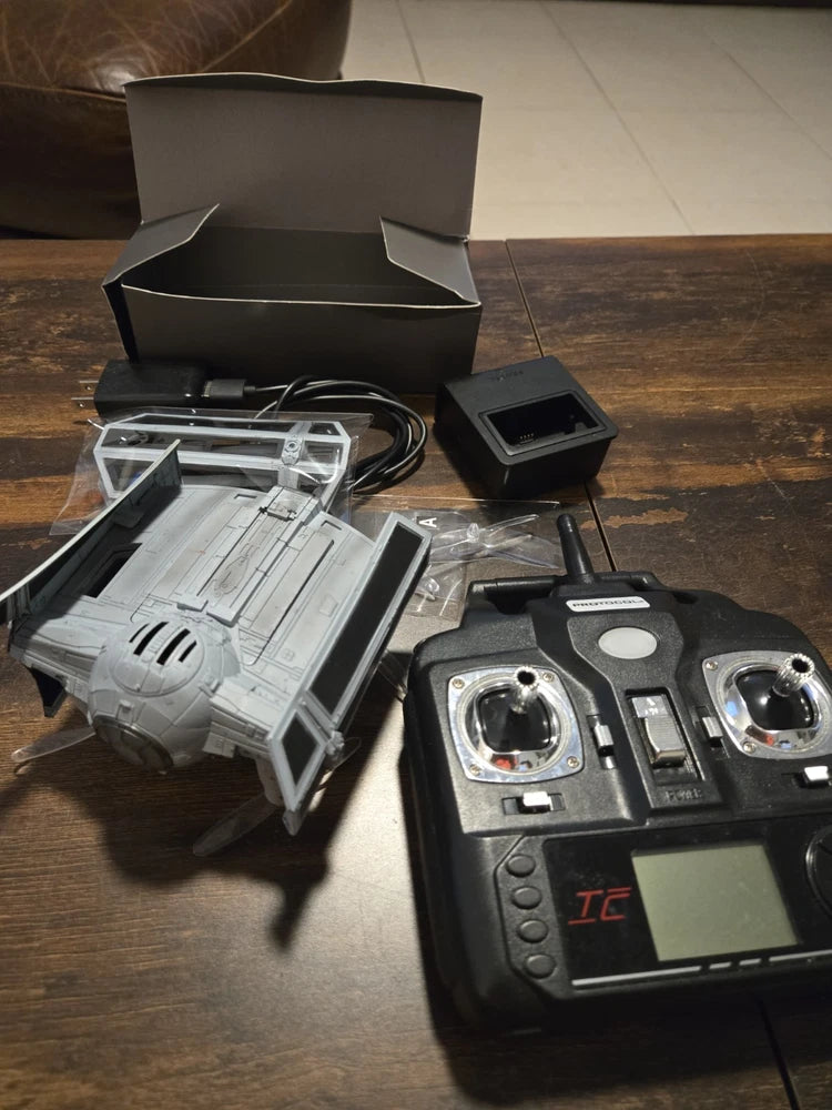 Tie Fighter RC drone toy with remote controller, open box, and accessories