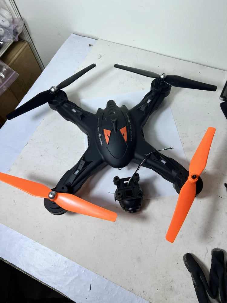 Black quadcopter drone with orange propellers and central camera module