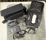 White quadcopter drone with controller, batteries, propellers, and case