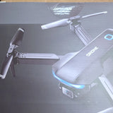 Foldable quadcopter drone with glowing LED light strip, gray/black body