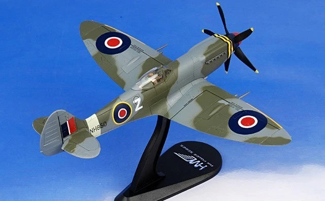 Green-and-white Spitfire model airplane with roundel markings on black stand