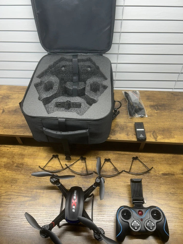 Quadcopter drone kit with open hard case, remote controller, and propellers