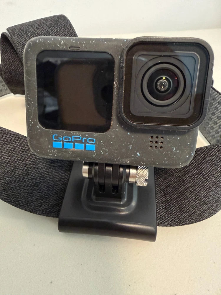 GoPro action camera with front lens and black head strap, rugged gray housing