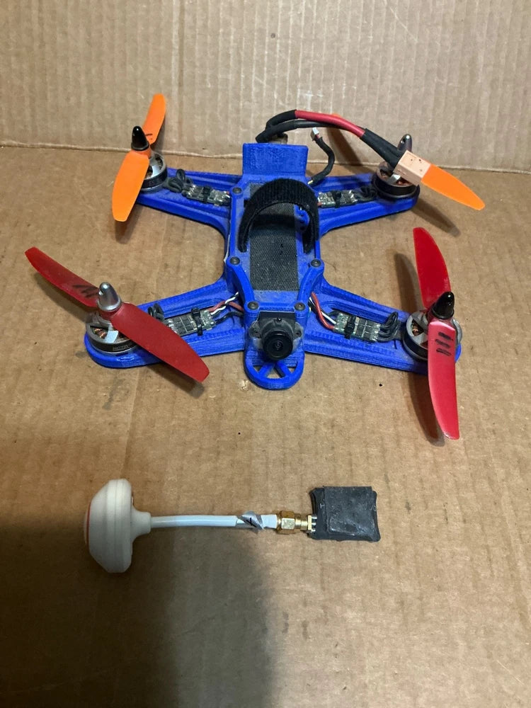 Used assembled quadcopter drone with blue frame, four propellers, control board and camera