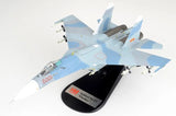 Light blue and white Su-27SK die-cast model aircraft on black display stand