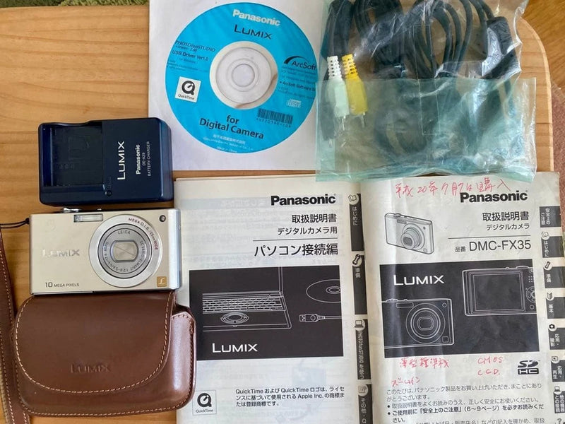 Silver compact Panasonic LUMIX digital camera with brown leather case
