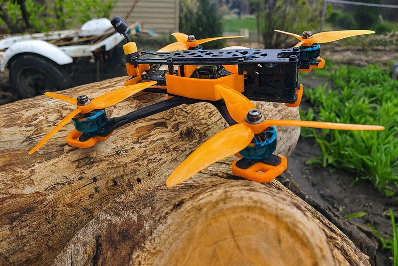 Orange quadcopter FPV drone with 4 propellers and FPV camera mount