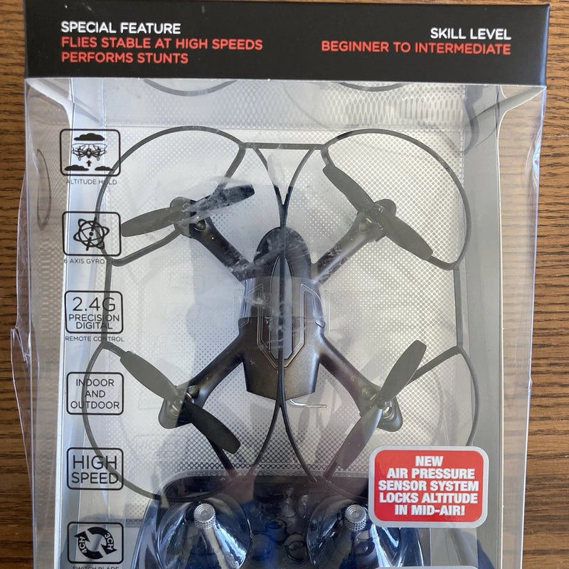Palm sized performance drone in clear box, propellers visible, red air pressure sensor label