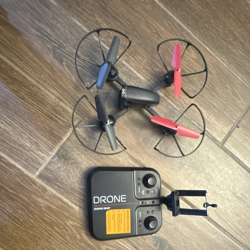 Black quadcopter drone with red propellers and remote controller