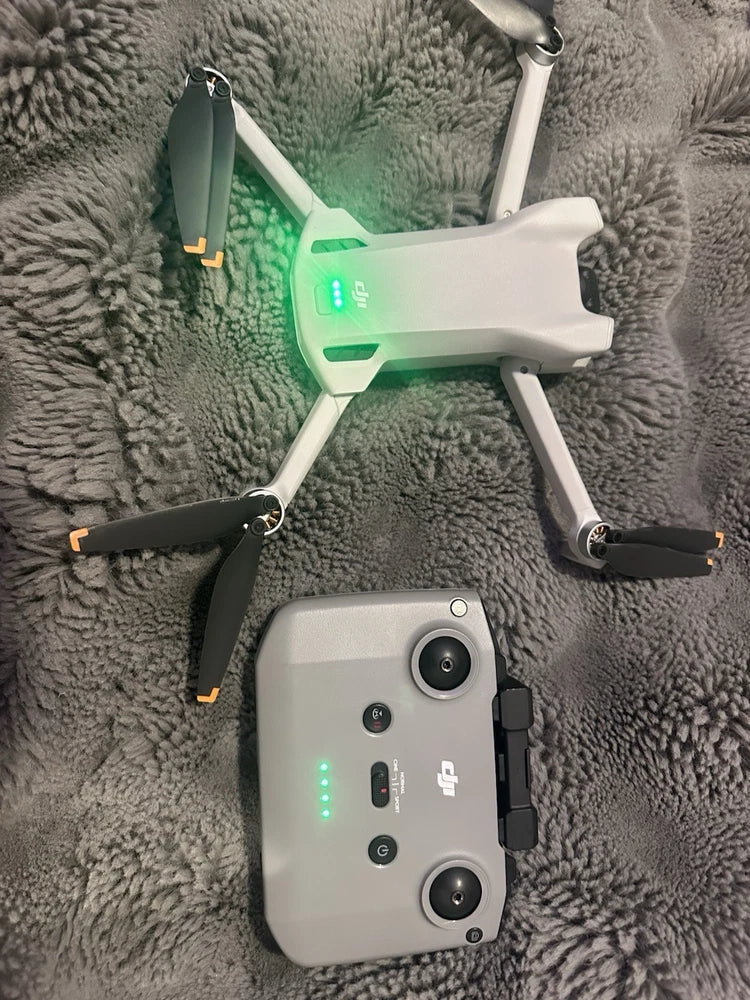 Foldable quadcopter drone with controller remote, white body, visible front camera