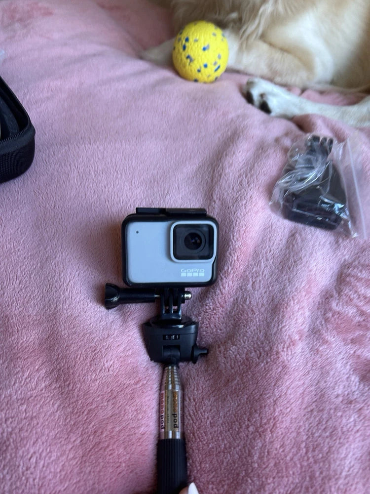 GoPro HERO7 action camera with mount and handle, plus small accessory bag