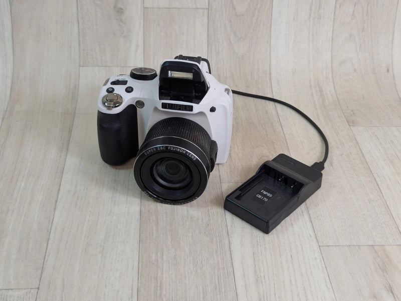 White digital bridge camera with lens and battery charger