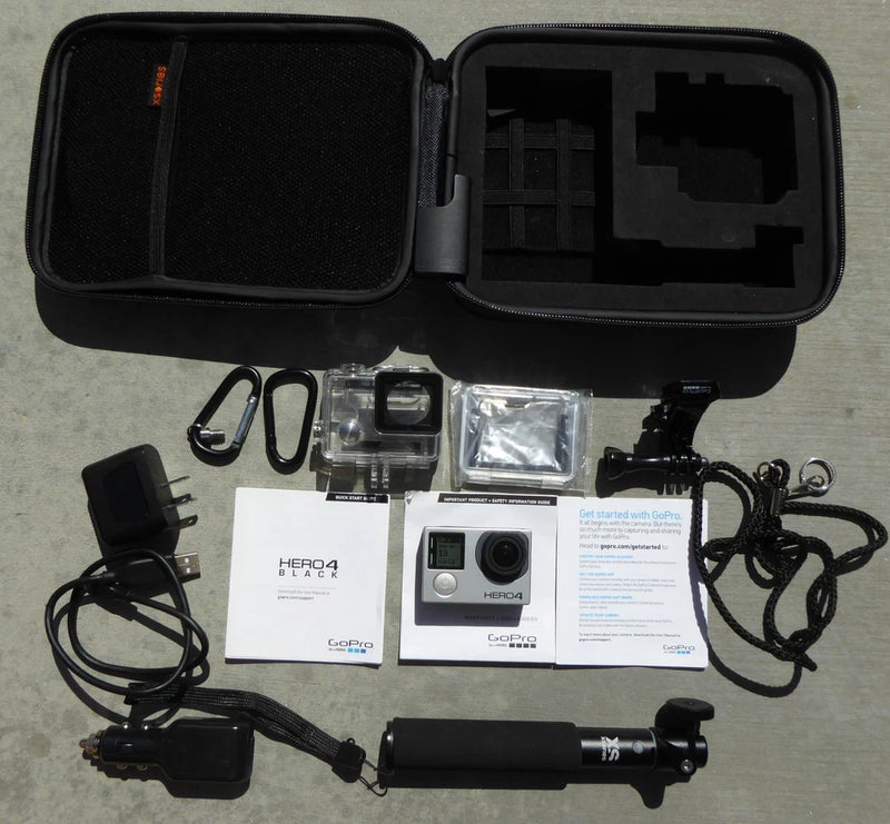 Black action camera in hard case with mounts, cables, waterproof housing, and quick-start guides