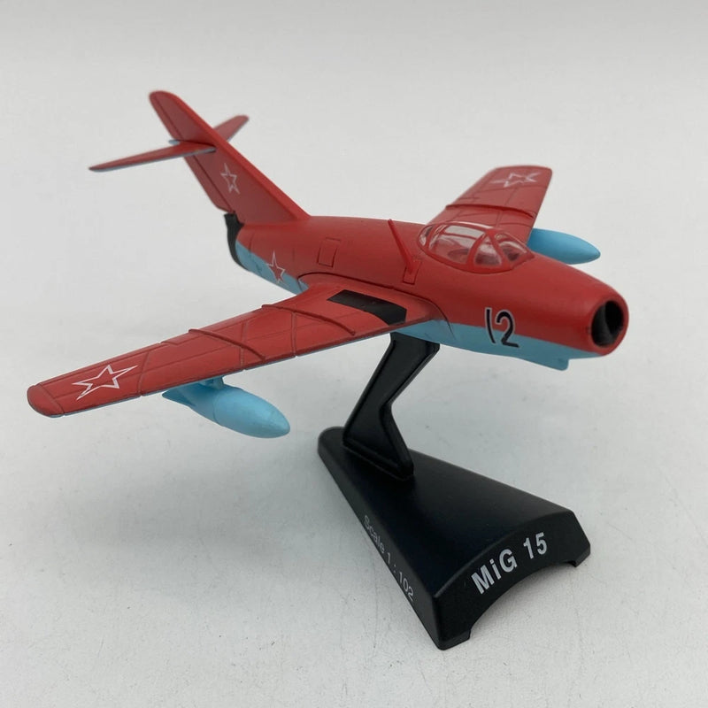Red MiG 15 die-cast airplane model with blue accents on black display stand