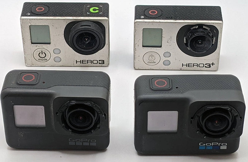 Four GoPro action cameras, front view, with lenses and LCD screens, for parts.
