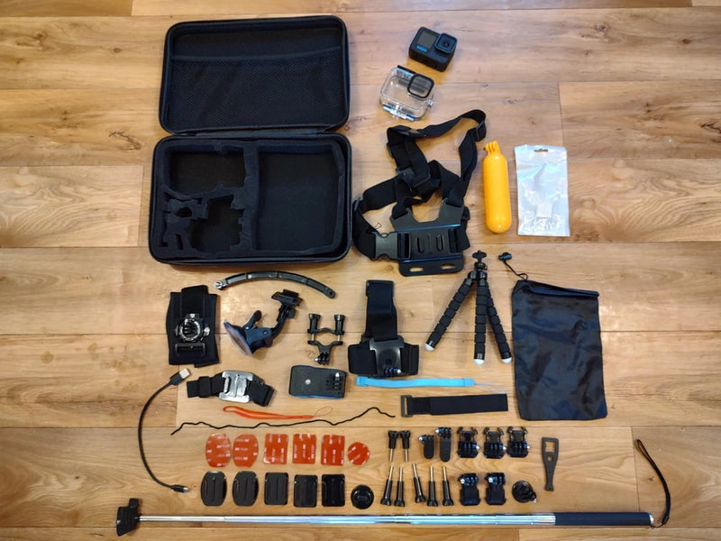 Black action camera accessory bundle with case, mounts, waterproof housing, and selfie stick