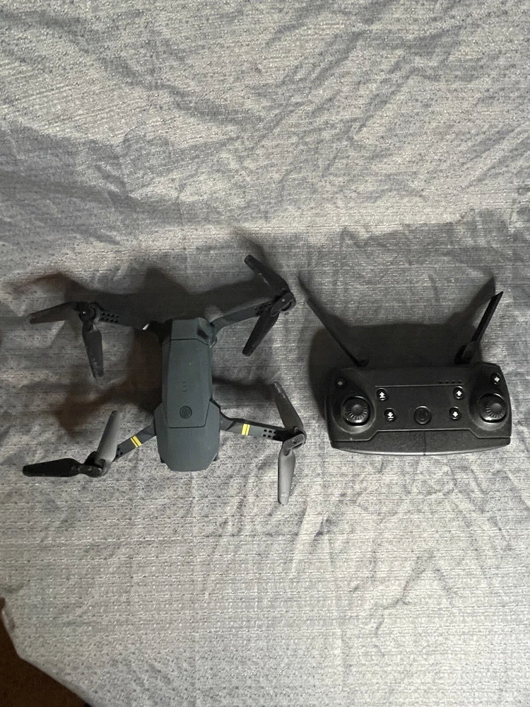 Rechargeable quadcopter drone with controller, grey body and propellers