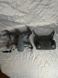 Rechargeable quadcopter drone with controller, grey body and propellers