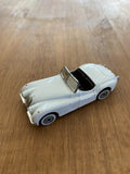 Die-cast convertible toy car model with light blue body and black top, front 3/4 view