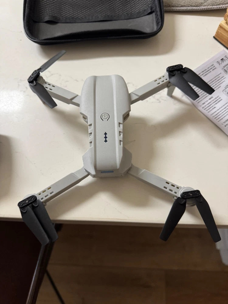 Foldable mini quadcopter drone with four propellers and white-gray body