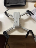 Foldable mini quadcopter drone with four propellers and white-gray body