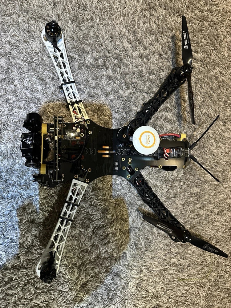 Black quadcopter discovery drone with four propeller arms and central control plate