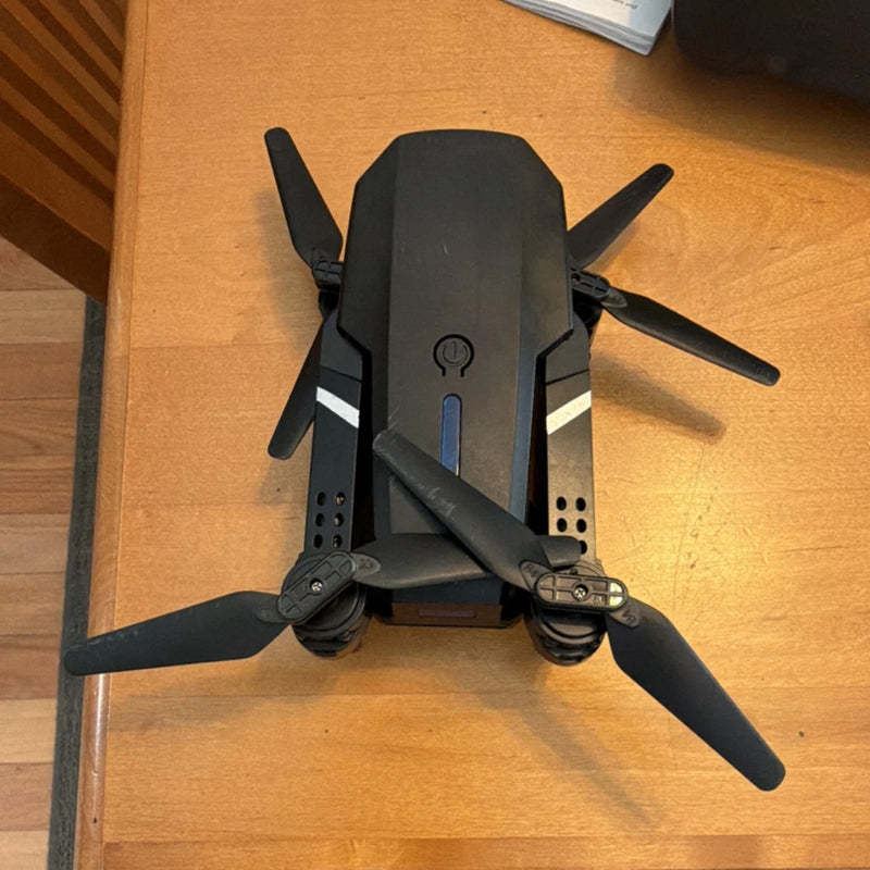 Foldable quadcopter drone with propeller guards, four folded dark-gray blades
