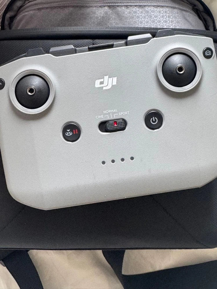 DJI drone controller with dual thumb joysticks and power buttons