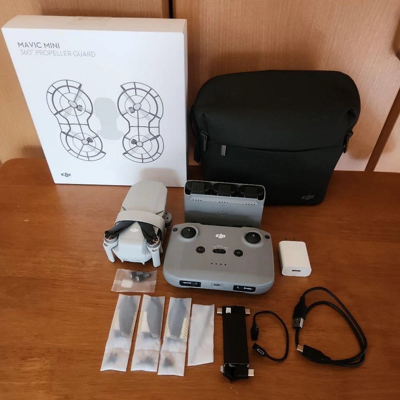 Compact quadcopter drone kit with controller, battery, cables, prop guards and parts