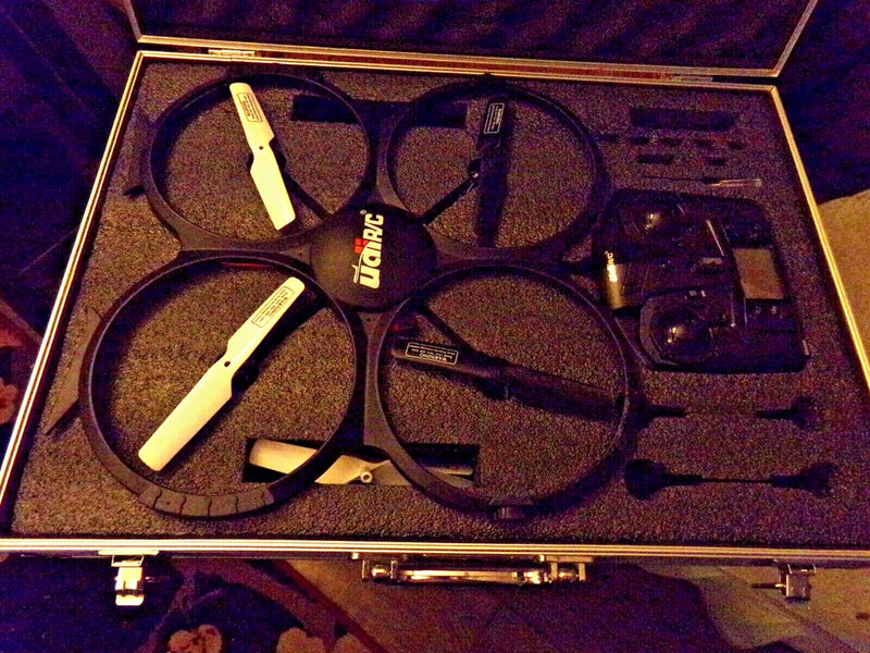 Quad copter drone with white propellers in open metal case