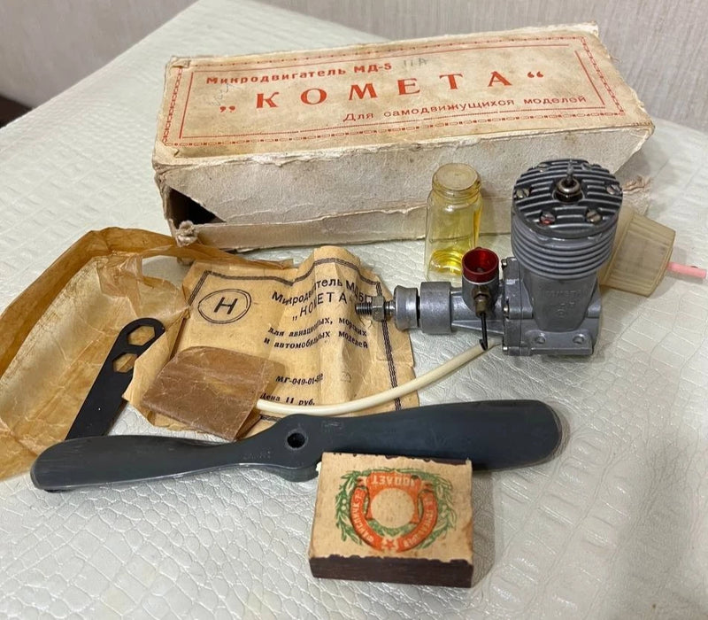 Vintage model motor engine kit with cylinder, propeller blade, and boxed parts