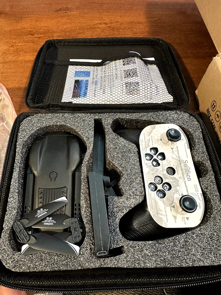 Black mini camera drone kit with controller, spare parts, and transmitter in hard case