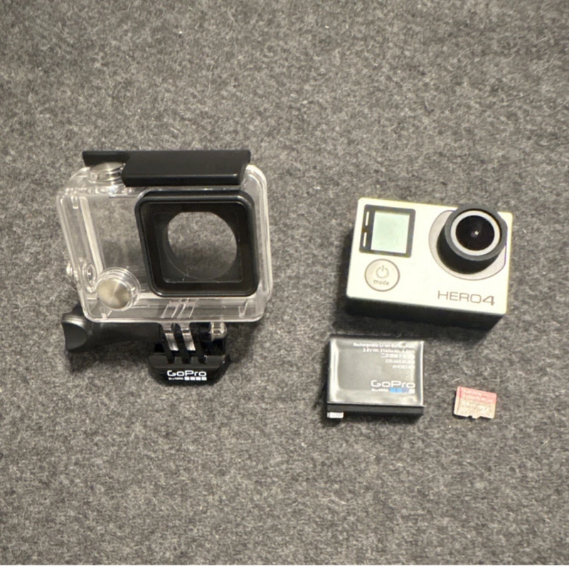 GoPro HERO4 action camera with clear waterproof housing, battery, and microSD card