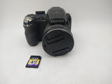 Black Fujifilm FinePix compact digital camera with lens and Lexar 4GB SD card