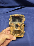 Camouflaged trail hunting camera with front lens and window display