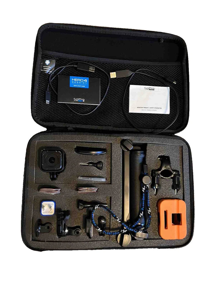 Black action camera in hard case with accessories, mounts, battery, and orange module