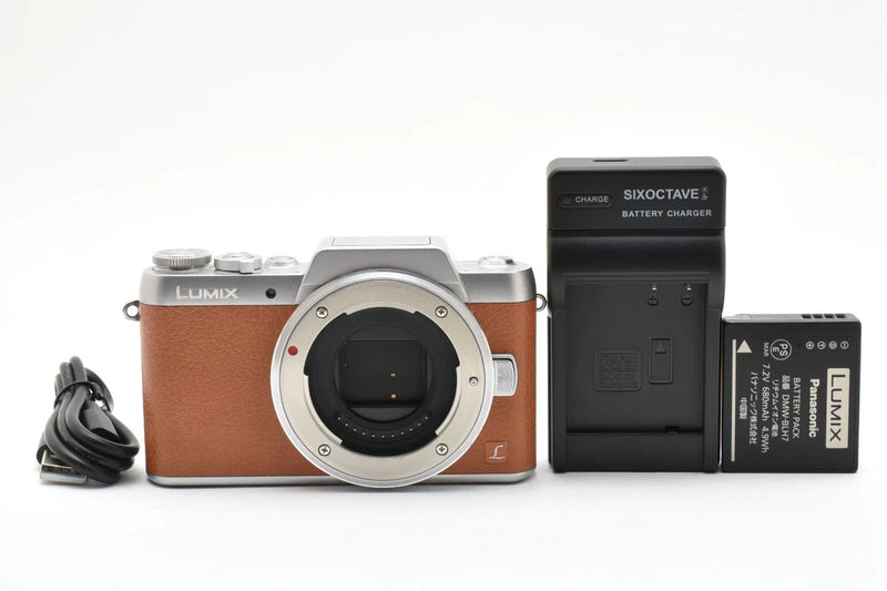 Brown Panasonic Lumix DMC-GF7 camera body with lens mount and battery charger